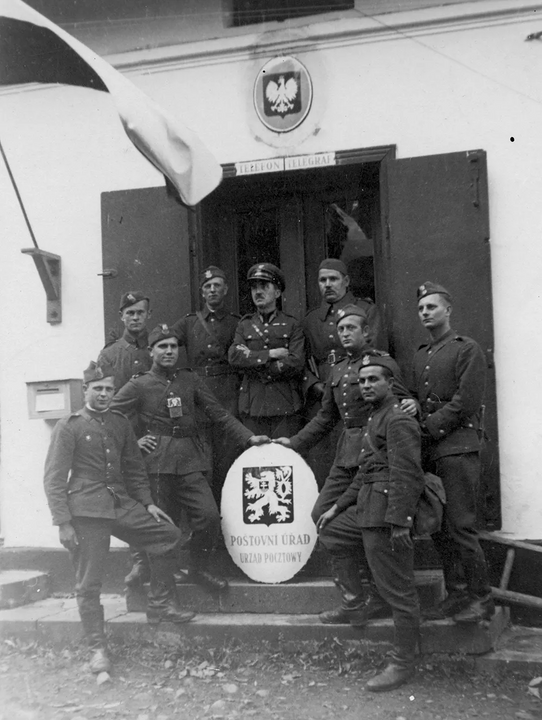 <i>Lính Ba Lan gỡ quốc huy Tiệp Khắc xuống, treo cờ và quốc huy Ba Lan lên, tại bưu điện của làng Komorní Lhotka, Tiệp Khắc.</i>