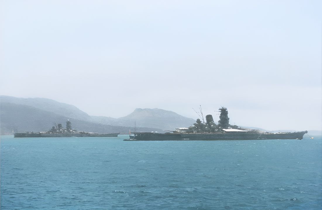 Yamato (bên trái) và Musashi (bên phải) neo đậu tại đầm phá Truk vào một thời điểm nào đó trong năm 1943. Cả hai con tàu đã trải qua phần lớn năm đó neo ở tại đây — căn cứ chủ lực của Hải quân Đế quốc Nhật Bản ở Trung tâm Thái Bình Dương — mà không tham gia bất kỳ hoạt động tác chiến nào. (Naval History and Heritage Command, Photo Archives, Naval Subject Collection) 