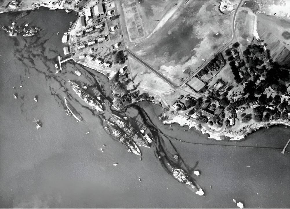 Cảnh chụp dãy thiết giáp hạm vào ngày 10 tháng 12 cho thấy hậu quả của trận tập kích Nhật Bản. Góc trên bên trái là California, đã chìm xuống đáy cảng. Từ trái sang phải là: Maryland (hư hại nhẹ) với Oklahoma bị lật neo ở ngoài, Tennessee (hư hại nhẹ) với West Virginia đã chìm ở ngoài, và Arizona với phần mũi bị phá hủy do vụ nổ hầm đạn. (NHHC)