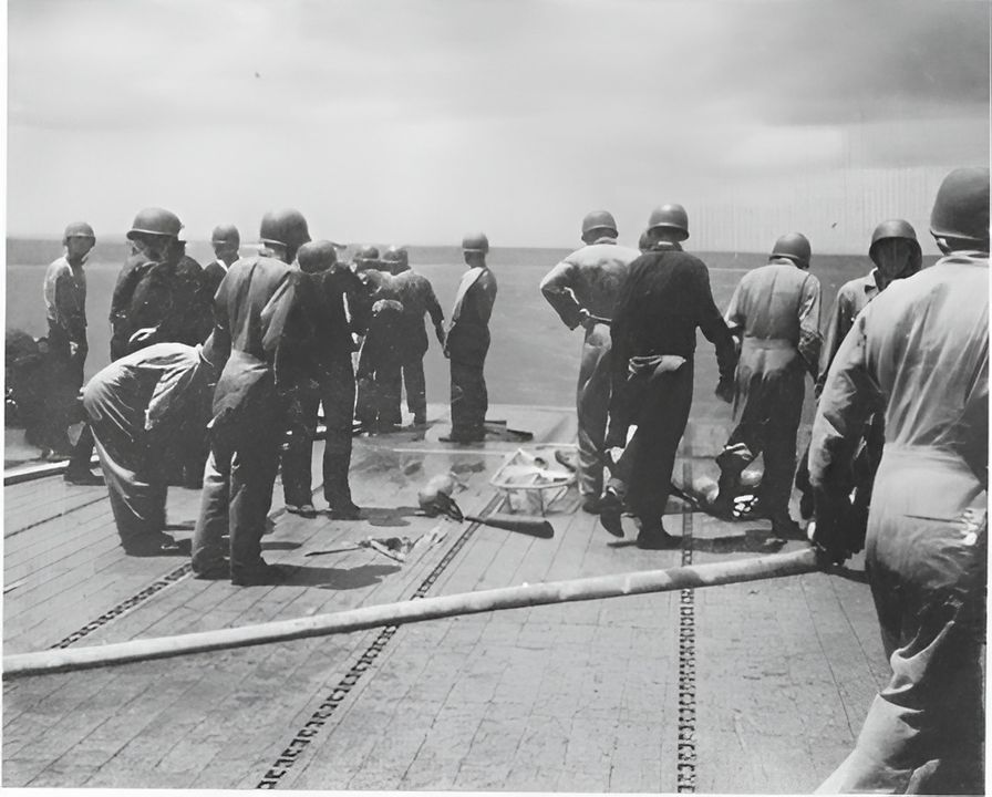 Ảnh chụp đội sửa chữa đến vị trí của quả bom thứ nhất trên sàn bay của Enterprise, có thể nhìn thấy ở chỗ những người thủy thủ đang đứng. (NHHC)