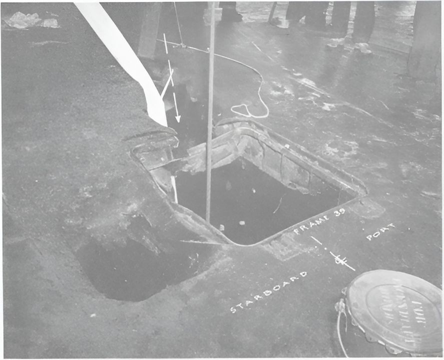 Cú đánh trúng thứ hai. Boong nhà chứa máy bay tại cửa hầm 1-39, nhìn về phía đuôi. Phần chính của quả bom xuyên qua boong ở phía sau cửa hầm, trên trục dọc giữa tàu. Phần đuôi quả bom va chạm và phát nổ ở mạn phải của cửa hầm. Có thể thấy hai chữ "starboard" (mạn phải) và "port" (mạn trái) được ghi gần chỗ bom rơi. (NHHC)