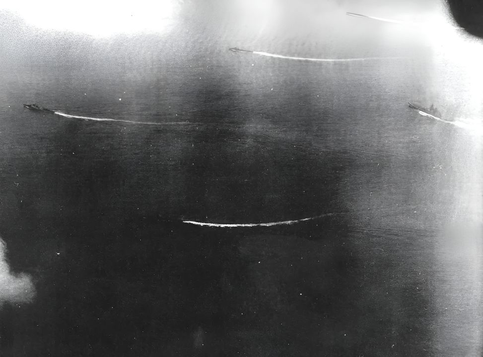 Yamato trong đội hình cùng bốn tàu khu trục, được chụp bởi một máy bay xuất phát từ Bennington. Bức ảnh này được chụp ngay trước đợt tấn công đầu tiên, vào khoảng 12 giờ 30 phút. (Naval History and Heritage Command, Photo Archives, Naval Subject Collection)