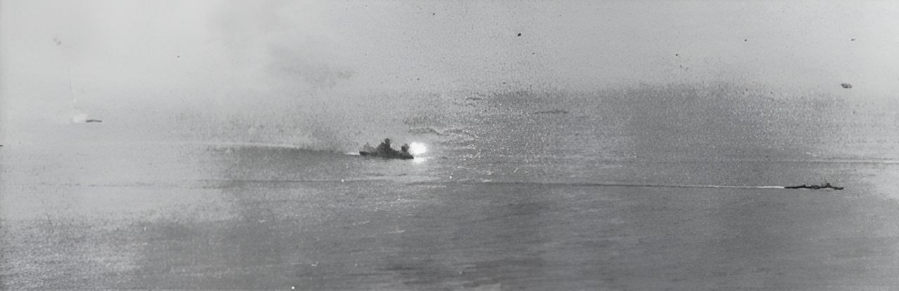 Ảnh chụp Yamato đang khai hỏa đạn phòng không Type 3 Sanshikidan từ pháo chính trong đợt tấn công đầu tiên của Mỹ. Trong ảnh có thể thấy 3 tàu khu trục đang đi chuyển xung quanh Yamato.