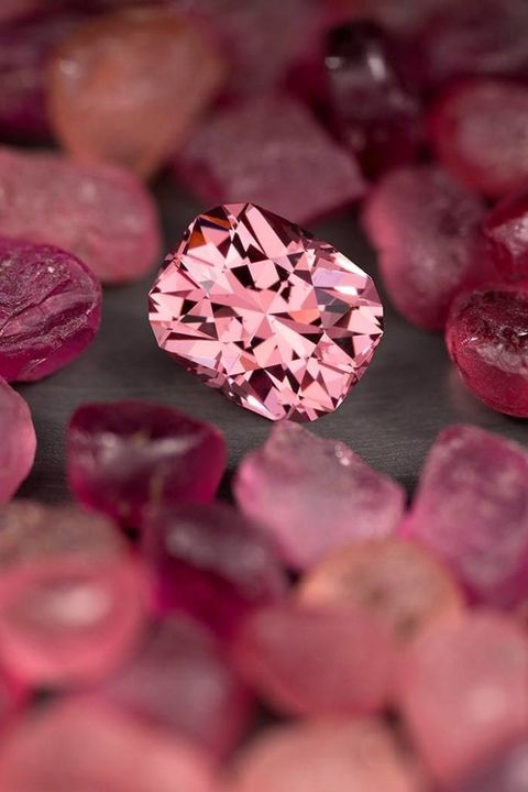Viên đá garnet mahenge cắt đệm 4,15 carat này được bao quanh bởi đá thô. © JL White Fine Gemstones