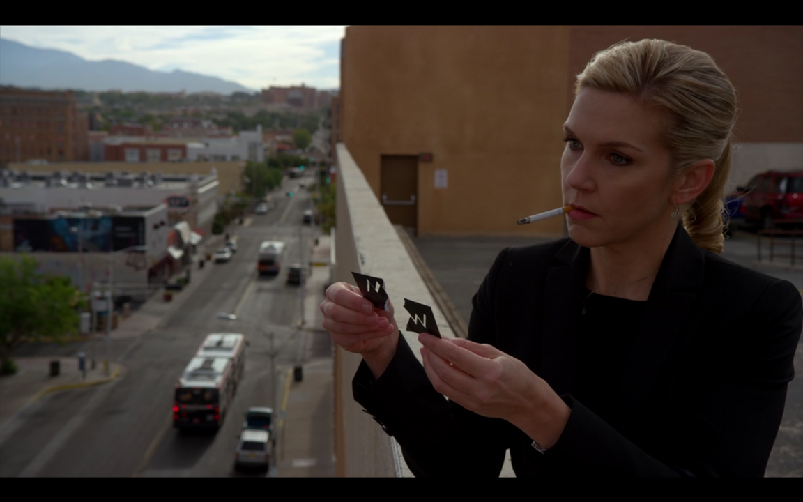 <i>Một phân cảnh khác tâm trạng của Kim được thể hiện bằng hình ảnh khi toàn bộ trang phục của cô đều màu đen, hút thuốc và tự tay xé tấm danh thiếp tách đôi phần tên của mình và Jimmy, ngụ ý cho một thứ quyền lực đang trỗi dậy, nó thuộc về bản ngã mới mẻ mà Kim mới tìm ra, và ở đó không có mối liên hệ nào với Jimmy. Có lẽ bởi nhân vật Kim Wexler có khá ít biểu cảm trên gương mặt nên cá tính của cô luôn được bộc lộ bởi hình ảnh, hành động và cử chỉ.</i>