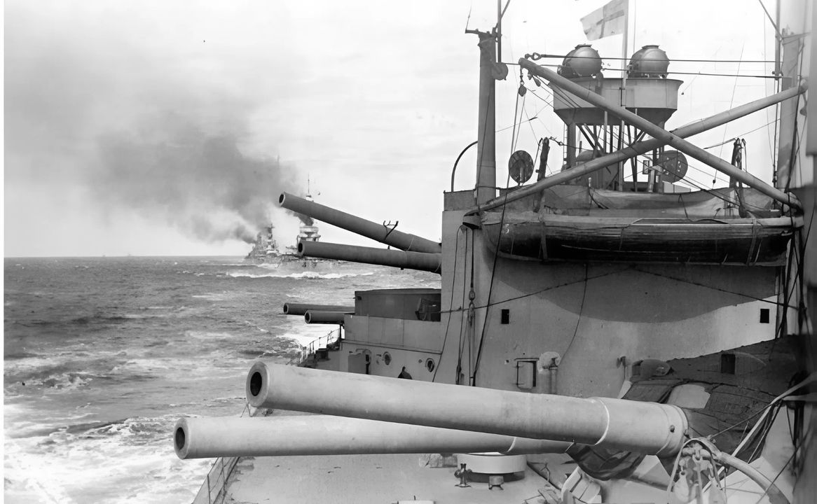 Các khẩu pháo 13½ inch của thiết giáp hạm HMS King George V, xoay về mạn phải trong một cuộc huấn luyện pháo binh trên Bắc Hải trong mùa đông 1917–18. Ở tiền cảnh là tháp pháo ‘Q’, lắp đặt ở giữa tàu, trong khi phía sau, sau cấu trúc thượng tầng đuôi tàu, là các khẩu pháo của tháp pháo ‘X’ bố trí bắn chồng, và tiếp đó là tháp pháo ‘Y’ ở phía đuôi tàu và thấp hơn chúng.