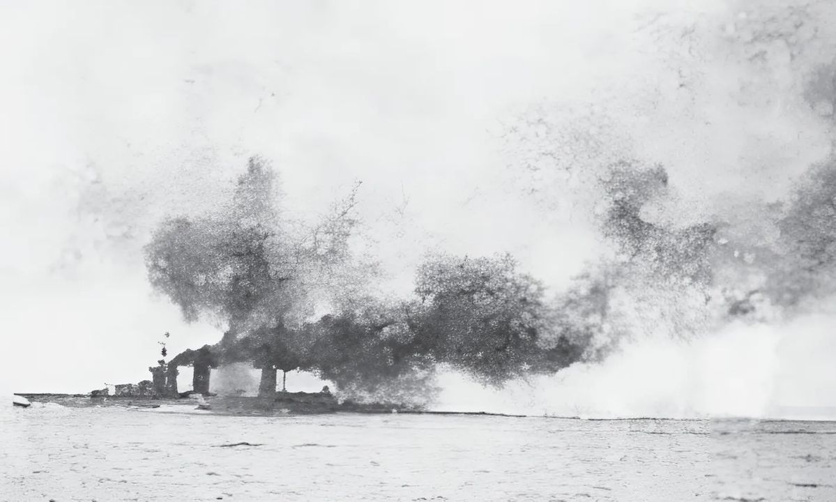 Chiếc Lion được nhìn thấy ở đường chân trời, đang bốc cháy sau khi bị trúng đạn pháo vào tháp pháo giữa tàu. Quả đạn đã xuyên phá lớp giáp của tháp pháo, gây ra một đám cháy, và 28 phút sau, ngọn lửa lan đến buồng nạp đạn, làm nổ tung tám liều thuốc phóng. (IWM SP 1704)