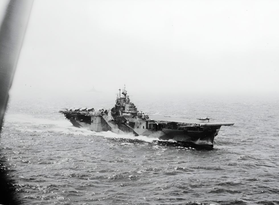 Ảnh chụp từ ghế sau của một chiếc máy bay ném bom SB2C Helldiver trong ngày 24 tháng 10 năm 1944 cho thấy tàu sân bay USS Intrepid (CV-11) đang thực hiện các hoạt động bay. Một chiếc SB2C khác thuộc Phi đội ném bom 18 (VB-18) đang cất cánh từ tàu sân bay. Lưu ý đến thiết giáp hạm ở phía xa.