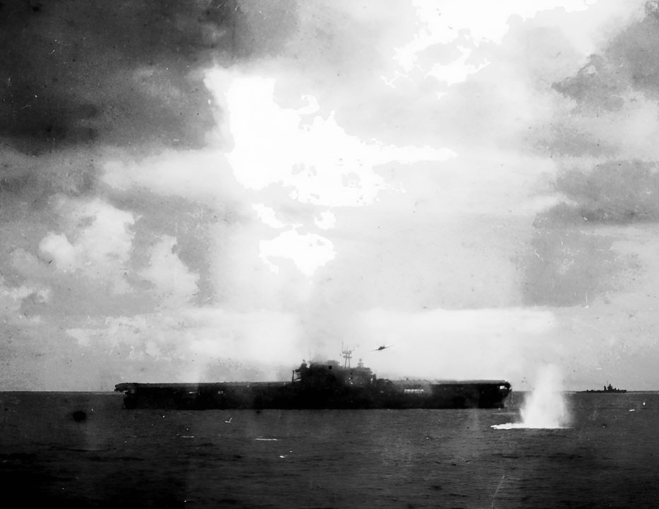 Một máy bay Type 97 (có thể nhìn thấy ngay phía trên và bên phải đảo chỉ huy của tàu Hornet) đã thả một quả ngư lôi (vệt nước bắn tung tóe ở phía dưới bên phải) và đánh trúng tàu sân bay, gây thiệt hại nghiêm trọng. Ảnh chụp từ USS Pensacola. (NHHC)