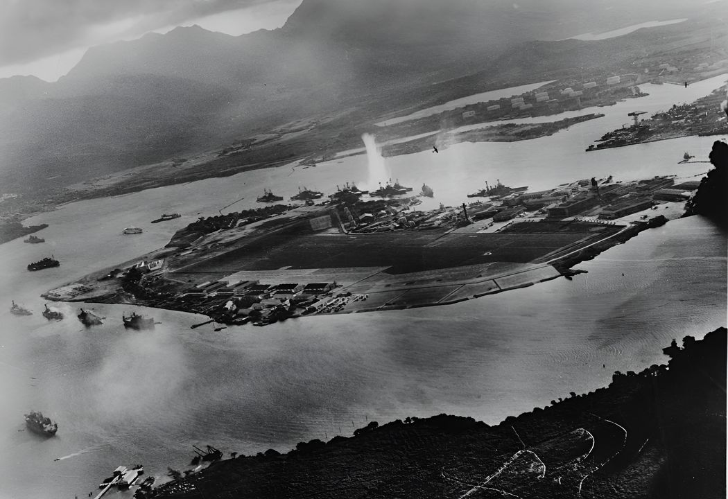 Bức ảnh đặc biệt này được chụp từ một máy bay Type 97 trong giai đoạn đầu của trận tấn công. Một quả ngư lôi vừa đánh trúng thiết giáp hạm West Virginia ở phía xa đảo Ford. Tàu Oklahoma, thiết giáp hạm neo ngoài, cũng đã trúng ngư lôi và đang nghiêng sang mạn trái. Hai chiếc Type 97 đang vòng ra khỏi dãy thiết giáp hạm sau khi thả vũ khí. Bên trái là bờ tây đảo Ford với các tàu Detroit, Raleigh, Utah, và Tangier. Raleigh và Utah đã bị trúng ngư lôi, Utah nghiêng mạnh sang trái. (NHHC)