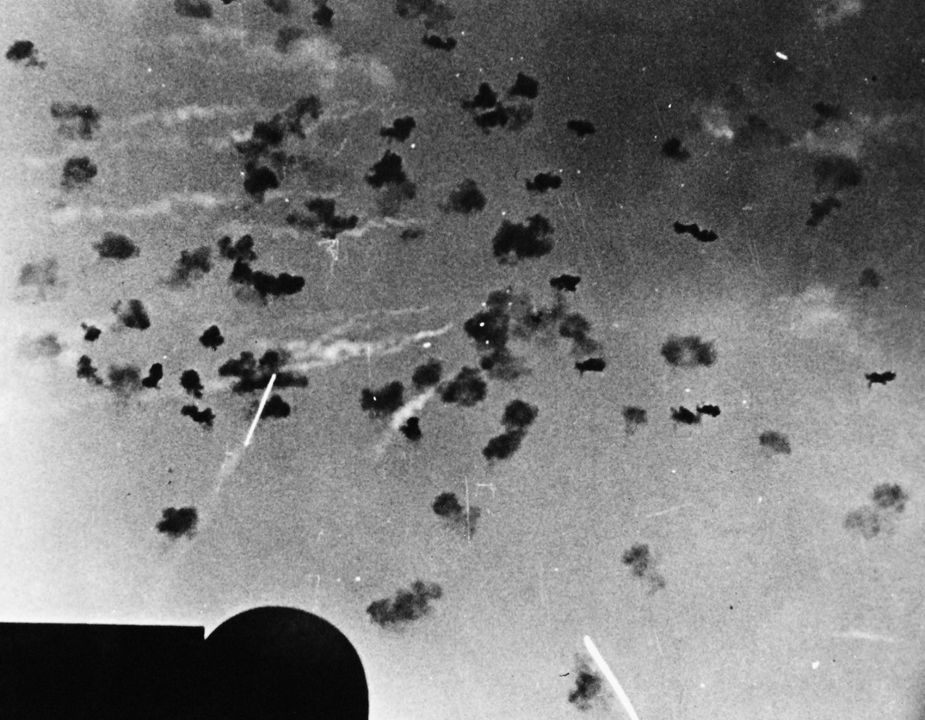 Máy bay Nhật Bản (ở giữa bên phải) chiến đấu trong làn đạn phòng không dày đặc từ các tàu hộ tống. Ảnh chụp bởi tàu USS San Juan. (NHHC)