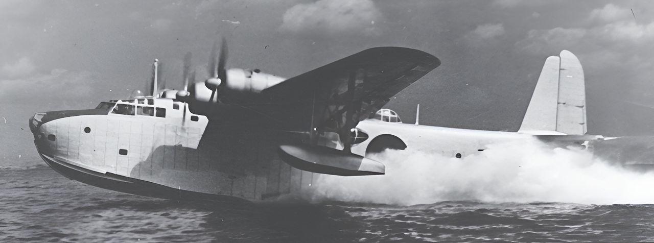 Mẫu thử nghiệm thuyền bay 13-Shi của Kawanishi được chụp tại cảng Kobe trong các cuộc bay thử đầu năm 1941. Máy bay đang thực hiện các chuyến chạy đà cất cánh thử nghiệm sau khi kỹ sư công ty gắn thêm dải giảm bắn nước dọc thân dưới. (2008-3-31_image_511_01, Bộ sưu tập Peter M. Bowers, MoF)