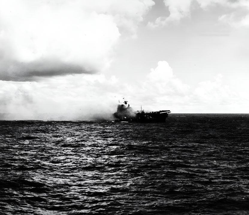 Ảnh chụp Hornet bị bốc cháy do quả bom xuyên qua boong chứa máy bay của con tàu. Con tàu cũng bị trúng quả ngư lôi đánh trống đợt tấn công thứ hai của người Nhật. Ảnh chụp từ USS Pensacola. (NHHC)