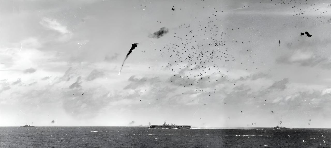 Một chiếc máy bay Nhật từ "Đợt Không kích lần II" bị bắn rơi trên không phận TG 58.3 ngay trước buổi trưa. Tàu sân bay hạng nhẹ trong hình có lẽ là Princeton, vốn bị ba máy bay tấn công. (NHHC)