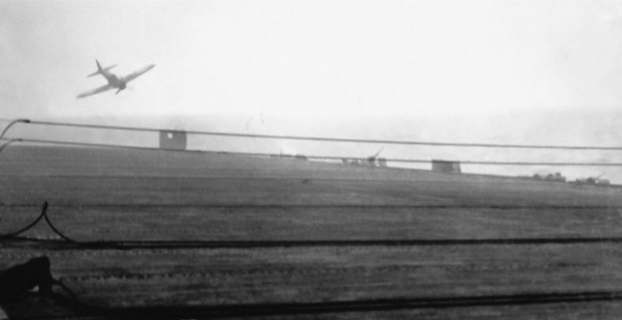 Bức ảnh đáng kinh ngạc này chụp ngày 25 tháng 10 năm 1944, khi chiến dịch kamikaze mở màn. Trong trường hợp này, một chiếc Zero-sen đang bổ nhào vào tàu sân bay hộ tống USS White Plains (CVE-66). Vụ tấn công cho thấy khó khăn vốn có khi cố tình đâm máy bay vào một con tàu. Chiếc Zero-sen tiếp cận từ góc sau mạn phải, nhưng đang quay phải để đánh trúng tàu sân bay. Máy bay đã trượt mục tiêu, nhưng lao xuống gần mạn trái. Cú sốc từ quả bom nổ đã buộc tàu sân bay phải quay về sửa chữa. (NARA)