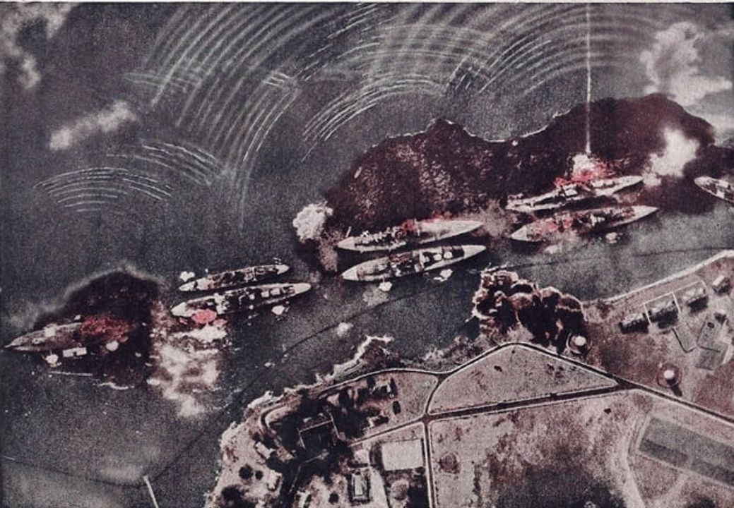 Đây là một góc nhìn thẳng đứng của khu vực dãy thiết giáp hạm (Battleship Row), được chụp từ một chiếc B5N2. Các tàu có thể nhìn thấy từ trái sang phải gồm: Nevada, Arizona với tàu sửa chữa Vestal neo ở mạn ngoài, Tennessee với West Virginia neo phía ngoài, Maryland với Oklahoma neo ngoài cùng, và tàu tiếp dầu Neosho chỉ lộ một phần ở mép phải ảnh. Một quả bom vừa đánh trúng Arizona gần phần đuôi tàu, nhưng vẫn chưa phải là quả bom đã kích nổ kho đạn phía trước. West Virginia và Oklahoma đã bắt đầu phun dầu từ nhiều vết trúng ngư lôi và đang nghiêng về mạn trái. Thực vậy, mép boong bên trái của tàu Oklahoma lúc này đã chìm dưới mặt nước. (NHHC)