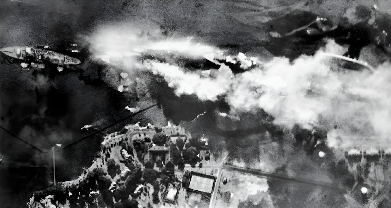 Ảnh chụp thẳng đứng  dãy thiết giáp hạm ngay sau khi Arizona bị trúng quả bom xuyên giáp nặng 1.764 lb khiến hầm đạn phía trước phát nổ, phá hủy con tàu. Từ trái sang phải: Nevada, Arizona (đang cháy dữ dội) với Vestal neo ở ngoài, Tennessee với West Virginia ở ngoài, và Maryland với Oklahoma đã lật úp. (NHHC)