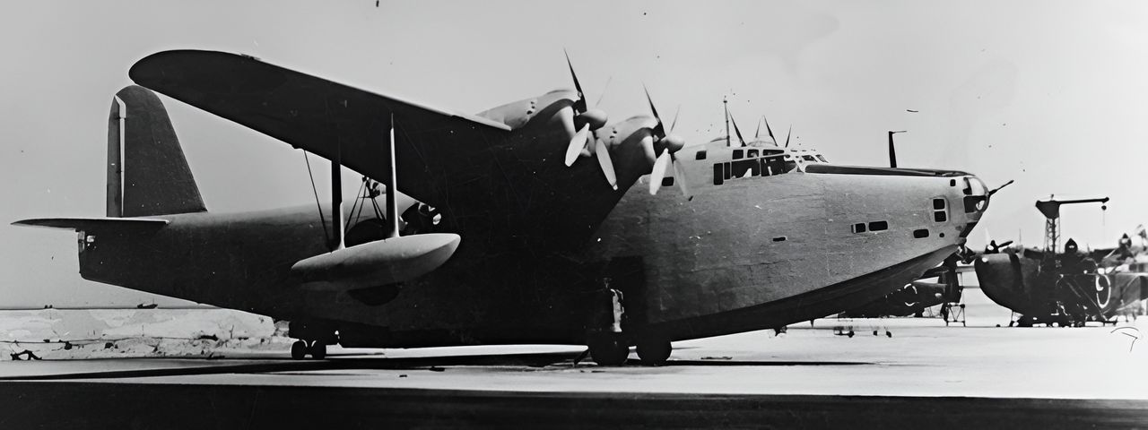 Nguyên mẫu thứ hai của thuyền bay 13-Shi, cũng là chiếc đầu tiên của dòng H8K1, có hình dạng bánh lái được sửa đổi, thân sâu hơn, và mũi kéo dài để lắp tháp pháo gắn pháo Type 99 20mm. Các H8K1 sản xuất sớm có thể thấy đang được chế tạo phía sau nguyên mẫu này. (2008-3-31_image_512_01, Bộ sưu tập Peter M. Bowers, MoF)