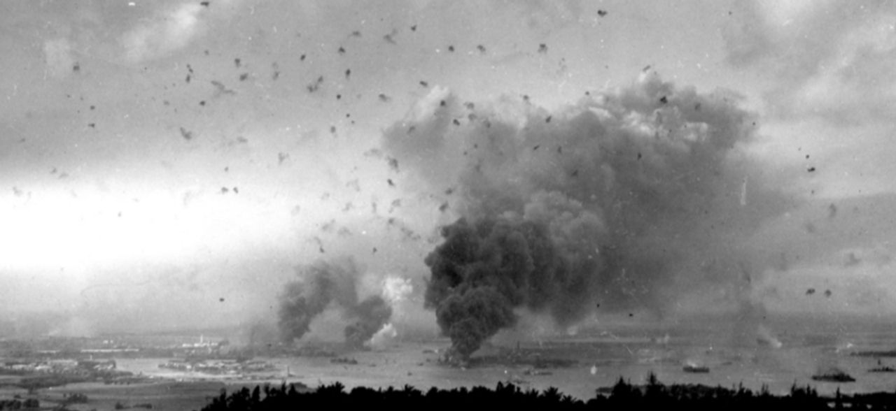 Bức ảnh toàn cảnh này về Trân Châu Cảng được chụp trong đợt tấn công thứ hai. Nhiều chi tiết có thể được nhận ra từ bức ảnh này. Cột khói lớn ở giữa góc dưới bên phải là từ Arizona đang bốc cháy. Hai cột khói phía bên trái là từ các tàu khu trục Shaw, Cassin và Downes, đang cháy trong hai ụ tàu khô. Chú ý lượng hỏa lực phòng không dày đặc, cho thấy lực lượng Mỹ đã nhanh chóng hồi phục sau cú sốc ban đầu. Quan trọng hơn cả, bức ảnh này cho thấy lý do vì sao các máy bay ném bom bổ nhào trong đợt tấn công thứ hai lại đạt kết quả kém. Không chỉ phải đối mặt với khói dày và hỏa lực phòng không, mà còn có một lớp mây thấp bao phủ khu vực cảng. (NHHC)