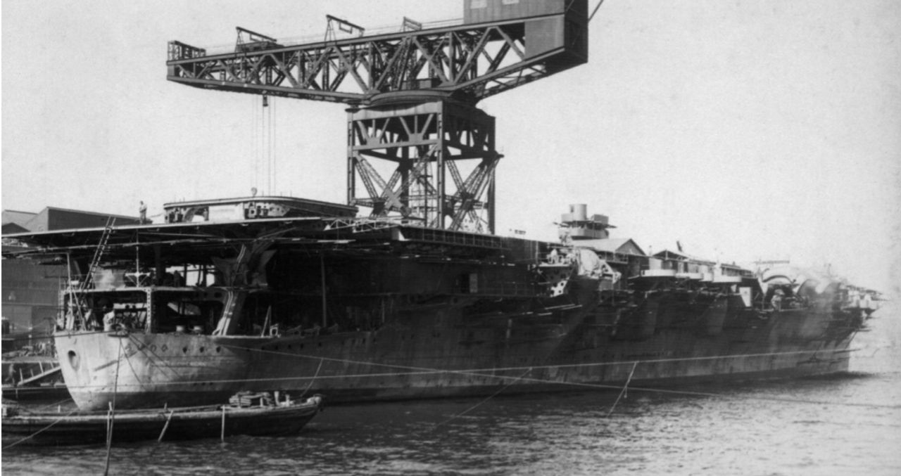 Hiryū trong giai đoạn cuối của quá trình hoàn tất trang bị tại Bể Koumi của Xưởng hải quân Yokosuka vào ngày 20 tháng 2 năm 1939. Thang nâng máy bay phía sau đang được hạ vào vị trí bằng một cần cẩu 200 tấn, và làn khói từ ống khói cho thấy các nồi hơi đã được đốt lên. (Phòng Hàng không Hải quân Đế quốc Nhật Bản)