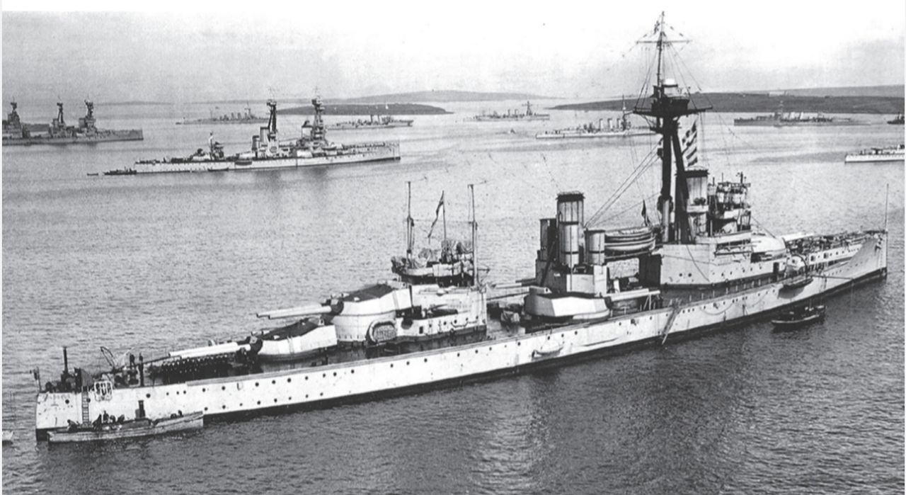 Thiết giáp hạm HMS Colossus, con tàu đặt tên cho lớp của mình, được chụp khi đang neo đậu tại Scapa Flow, trong khu neo chính của hạm đội ngoài khơi Flotta, nhìn về hướng đông. Ở hậu cảnh là các thiết giáp hạm lớp Bellerophon và St Vincent, cùng một số tàu tuần dương hạng nhẹ, với đảo nhỏ Calf of Flotta phía sau chúng, trong khi bên phải là một phần của đảo lớn Flotta.