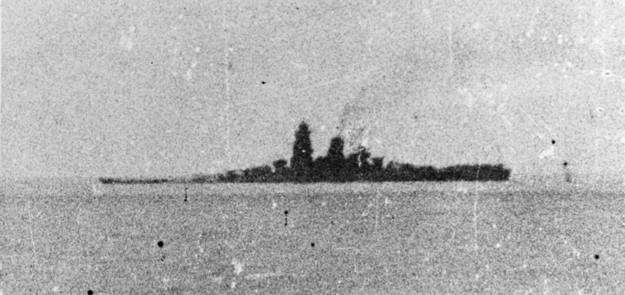 Bức ảnh chất lượng kém nhưng đầy kịch tính này cho thấy Musashi đã chúi mũi xuống rõ rệt. Con tàu vẫn giữ thăng bằng theo trục ngang, nhưng sẽ sớm chìm do ngập nước tiến triển. (Naval History and Heritage Command, Photo Archives, Naval Subject Collection)