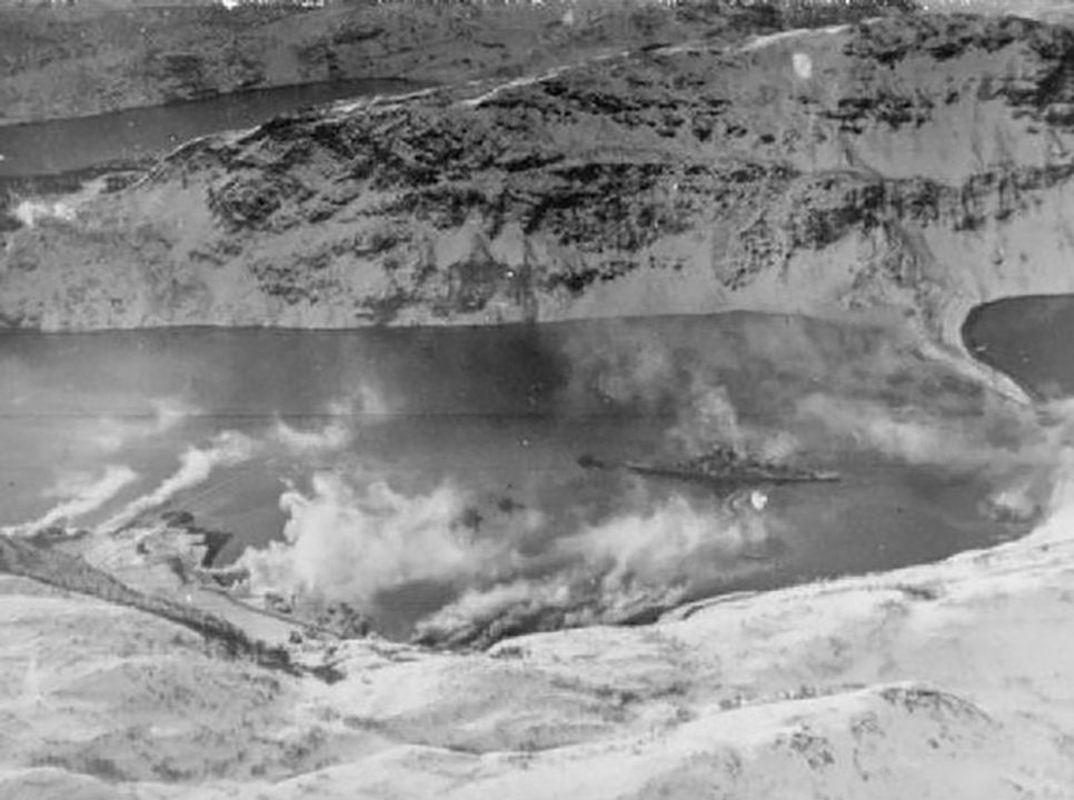 Tirpitz là thiết giáp hạm cuối cùng còn hoạt động của Hải quân Đức (Kriegsmarine). Tuy nhiên, sau khi bị hư hại vào tháng 9 năm 1943, nó không còn là mối đe dọa đối với các đoàn tàu vận tải Bắc Cực nữa. Bức ảnh này chụp Tirpitz tại Kåfjord, một nhánh của vịnh Altenfjord, trong một đợt tấn công của Không quân Hải quân Anh (Fleet Air Arm) vào tháng 4 năm 1944. Các máy tạo khói trên bờ đang tích cực tạo màn khói che giấu thiết giáp hạm