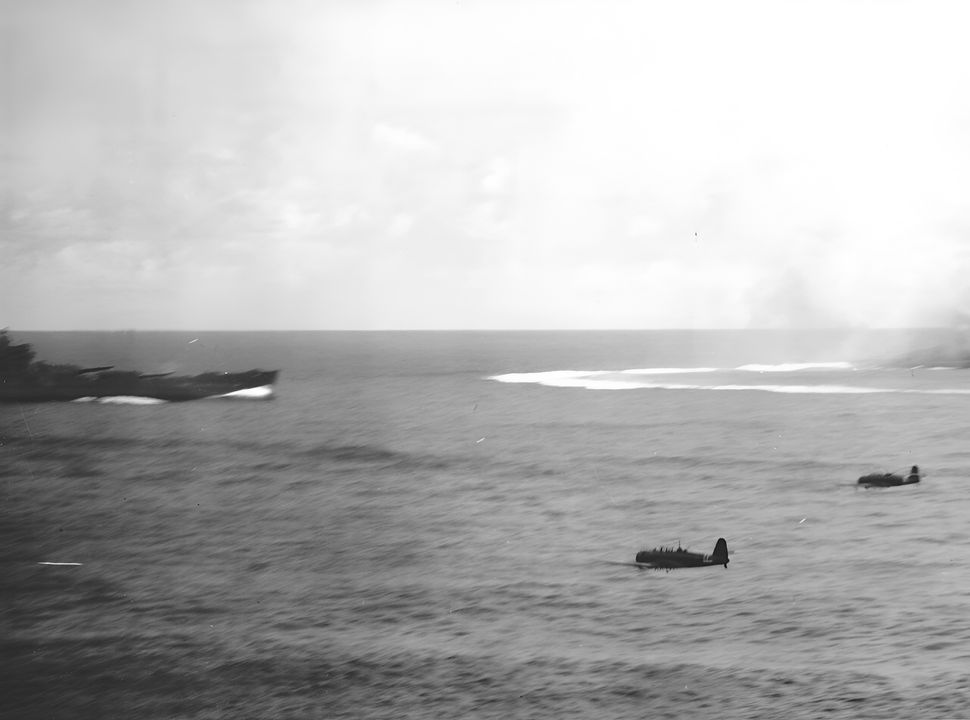 Sau khi thực hiện một cuộc tấn công ngư lôi không thành công vào tàu Enterprise, hai chiếc Type 97 từ tàu Zuikaku rời khu vực chiến đấu trong trận chiến quần đảo Santa Cruz bằng cách bay giữa mục tiêu và thiết giáp hạm South Dakota, mũi tàu của nó có thể nhìn thấy ở bên trái trong bức ảnh này được chụp từ đảo chỉ huy của tàu sân bay. (NHHC)