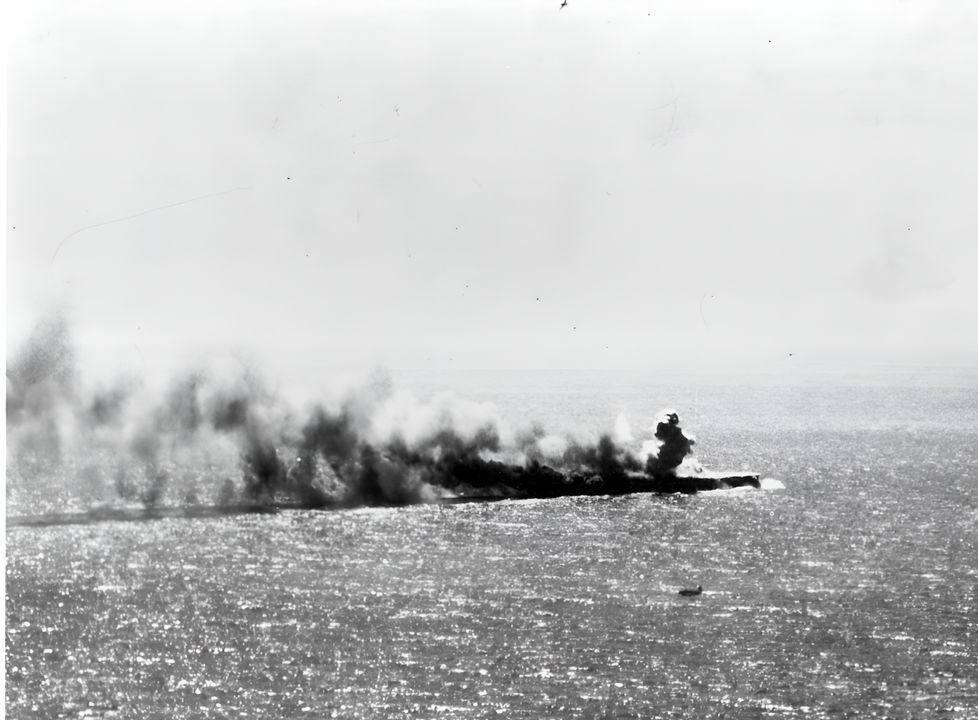 Bức ảnh được chụp từ máy bay của USS Yorktown ghi lại khoảnh khắc cuối cùng của Shoho, trước khi con tàu chìm không lâu sau đó. Chú ý một máy bay Mỹ ở trên mặt biển bay ngang qua con tàu (NHHC)