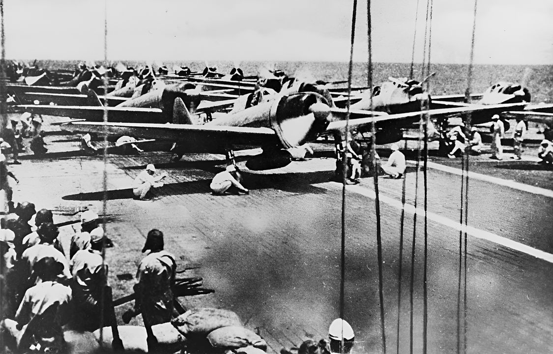 Bức ảnh này cho thấy một đợt tấn công chuẩn bị cất cánh từ Shokaku hoặc Zuikaku. Các máy bay tiêm kích Zero được bố trí phía trước vì chúng cần ít không gian hơn để cất cánh và các máy bay ném bom bổ nhào Type 99 nặng hơn được bố trí phía sau. Cảnh boong tàu này được cho là được chụp trong trận Santa Cruz.