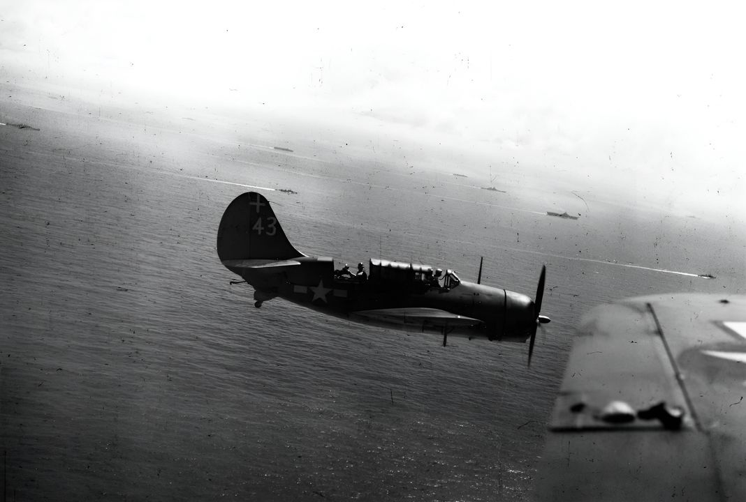 Một máy bay ném bom SB2C-3 Helldiver thuộc Phi đội ném bom 18 (VB-18) đang bay trên Nhóm tác chiến 38.2 (TG 38.2) trong trận chiến Biển Sibuyan ngày 24 tháng 10 năm 1944. Bức ảnh được chụp bởi Richard Shipman, một nhiếp ảnh gia từ tàu sân bay USS Intrepid (CV-11), từ ghế sau của một chiếc SB2C thuộc VB-18. Máy bay từ VB-18 đã tấn công các thiết giáp hạm Yamato và Musashi của Nhật Bản vào khoảng 10 giờ 30 phút. Các tàu sau đây có thể nhìn thấy: Intrepid và các tàu sân bay hạng nhẹ USS Independence (CVL-22) và USS Cabot (CVL-28). Phía bên trái và phía trước Intrepid là các thiết giáp hạm USS Iowa (BB-61) và USS New Jersey (BB-62).