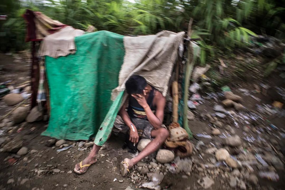 Một thợ mỏ đang tiêm heroin tại một "phòng tiêm chích" ở một mỏ khai thác ngọc bích tại Hpakant, Kachin, Myanmar. Thợ mỏ chỉ phải trả 2 đô la cho một mũi tiêm, và chính quyền đã nhắm mắt làm ngơ.