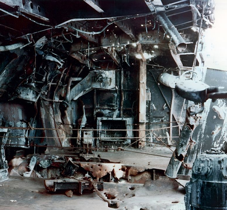 Không quả bom nào trong ba quả đánh trúng Enterprise gây ra hư hại mang tính chí mạng. Tác động của một trong những cú đánh được thể hiện trong bức ảnh này. Một quả bom nổ mạnh nặng 532 pound đánh trúng gần khẩu đội pháo 5 inch/38 ở mạn phải phía sau, và ngọn lửa bùng lên sau đó đã bao trùm toàn bộ vị trí khẩu đội, khiến toàn bộ 38 người của khẩu đội thiệt mạng và kích nổ các tủ đạn sẵn có của pháo 5 inch. (NHHC)