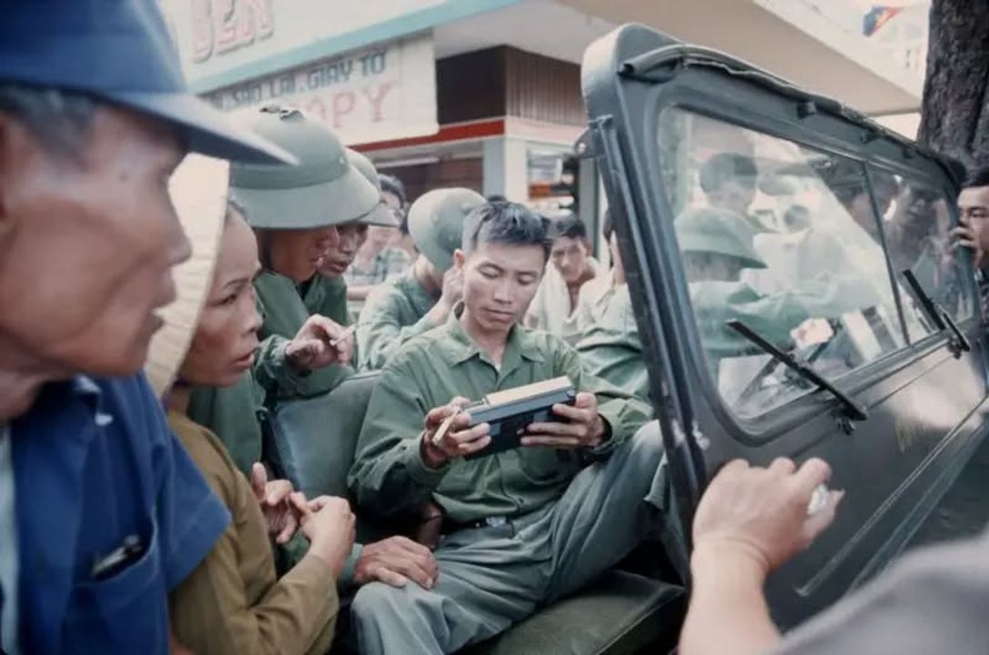Một cán bộ đang xem xét chiếc radio trên đường phố Sài Gòn sau ngày 30-4-1975 (Getty Image)