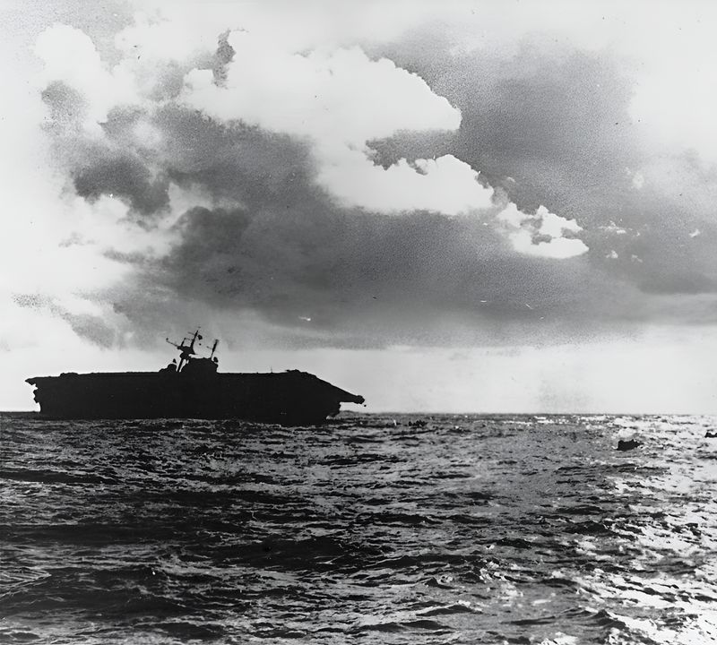 Đây ảnh chụp Hornet lúc 17 giờ. Con tàu đã bị bỏ sau khi chịu một trận oanh tạc khủng khiếp từ các cuộc không kích của Nhật. Một số thành viên thủy thủ đoàn có thể nhìn thấy trên bè cứu sinh bên phải. (NHHC)