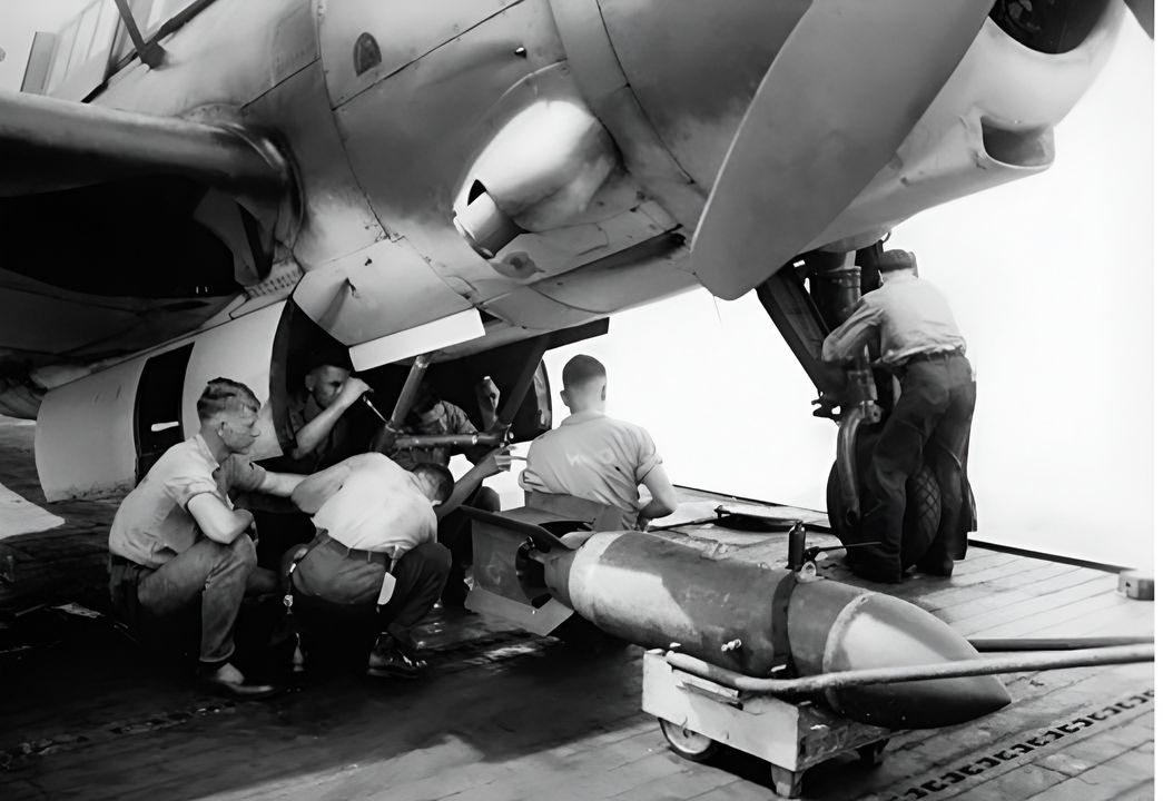Các thợ vũ khí thuộc VB-14 chuẩn bị nạp một quả bom xuyên giáp AN-Mk 33 nặng 1.000 lb vào khoang bom của một chiếc Helldiver trên USS Wasp (CV-18) năm 1944. Loại bom này có thể nhận biết nhờ mũi hình nón, và AN-Mk 33 được dành riêng để tấn công các tàu chiến bọc giáp dày. Ngoài ra còn có các loại bom bán xuyên giáp và bom thông thường nặng 500 và 1.000 lb, với vỏ mỏng hơn và lượng thuốc nổ lớn hơn – các loại sau có các cỡ 100, 250, 500, 1.000 và 2.000 lb, và đều có thể mang bởi Helldiver và Avenger. (Real War Photos)