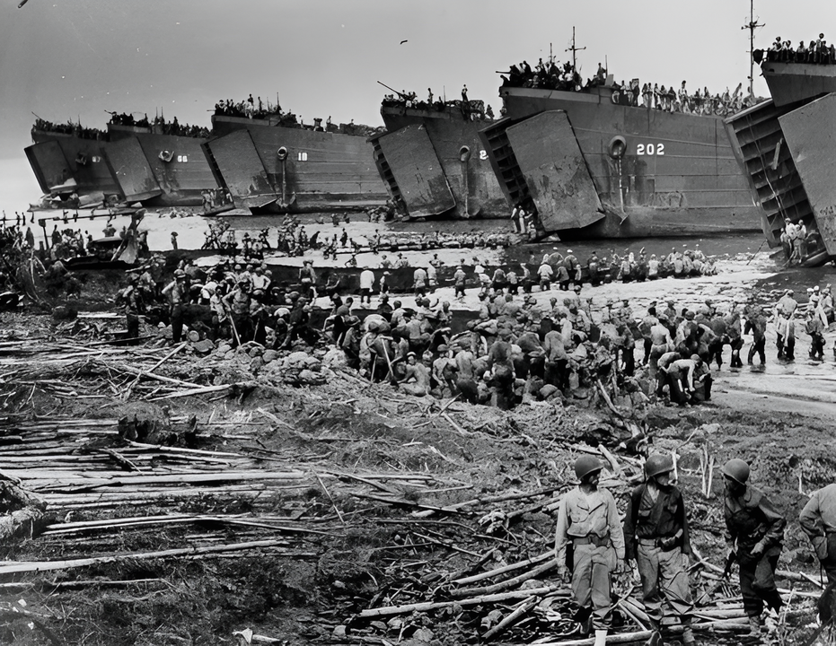 Cuộc đổ bộ lên Leyte, Philippine, vào ngày 20 tháng 10 năm 1944. Những "xe chở hàng" khổng lồ dỡ hàng hóa chiến tranh xuống Leyte. Một hạm đội gồm các tàu đổ bộ tăng (LST) do Lực lượng Bảo vệ bờ biển và Hải quân điều khiển, những phương tiện vận chuyển vật tư chiến tranh khổng lồ, đang dỡ hàng hóa lên bãi biển đảo Leyte vào đầu cuộc tấn công giải phóng ở miền trung Philippine. Trong khi các khẩu pháo phòng không từ mũi tàu chĩa lên bầu trời để đề phòng các cuộc không kích của Nhật Bản, hàng trăm binh sĩ Mỹ xây dựng các "bến tàu" dỡ hàng ra đến các đường dốc của tàu LST. Những con tàu này được xem là mục tiêu của Lực lượng Tấn công Nghi binh Thứ Nhất.