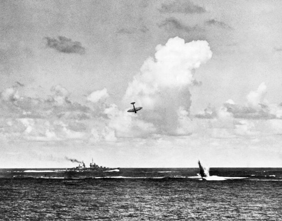 Một máy bay ném bom bổ nhào Type 99 của Nhật Bản rơi xuống cạnh tàu tuần dương hạng nhẹ USS San Diego (CL-53). Bên phải bức ảnh có thể thấy cột nước do chiếc Type 99 trước đó cũng bị hỏa lực phòng không bắn hạ và rơi xuống nước.