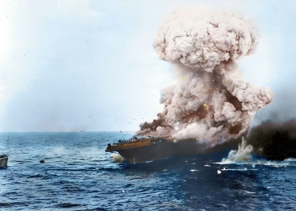 Bức ảnh này cho thấy một trong những vụ nổ lớn đã xé toạc sàn bay của con tàu, diễn ra trong quá trình thủy thủ đoàn đang rời tàu. Chú ý có thể thấy tàu Yorktown ở đường chân trời. (NHHC)