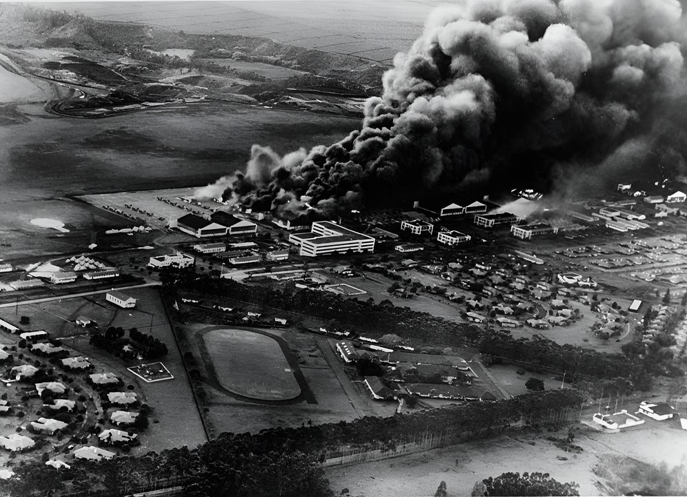 Máy bay và nhà chứa máy bay bốc cháy tại Sân bay Không quân Wheeler, Oahu, ngay sau khi nơi này bị tấn công vào sáng ngày 7 tháng 12 năm 1941, nhìn từ máy bay của Hải quân Nhật Bản.(NHHC)