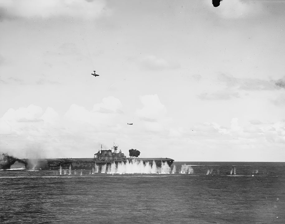 Góc nhìn đáng chú ý này, chụp từ tàu tuần dương hạng nặng Pensacola, cho thấy cuộc tấn công phối hợp hoàn chỉnh của Nhật vào Hornet đang diễn ra. Phía trên tàu sân bay là một máy bay ném bom bổ nhào Type 99 từ Zuikaku sắp đâm xuống tàu. Một máy bay ném ngư lôi Type 97 từ Shokaku cũng có thể nhìn thấy ở phía sau sau khi phóng ngư lôi vào Hornet. (NHHC)