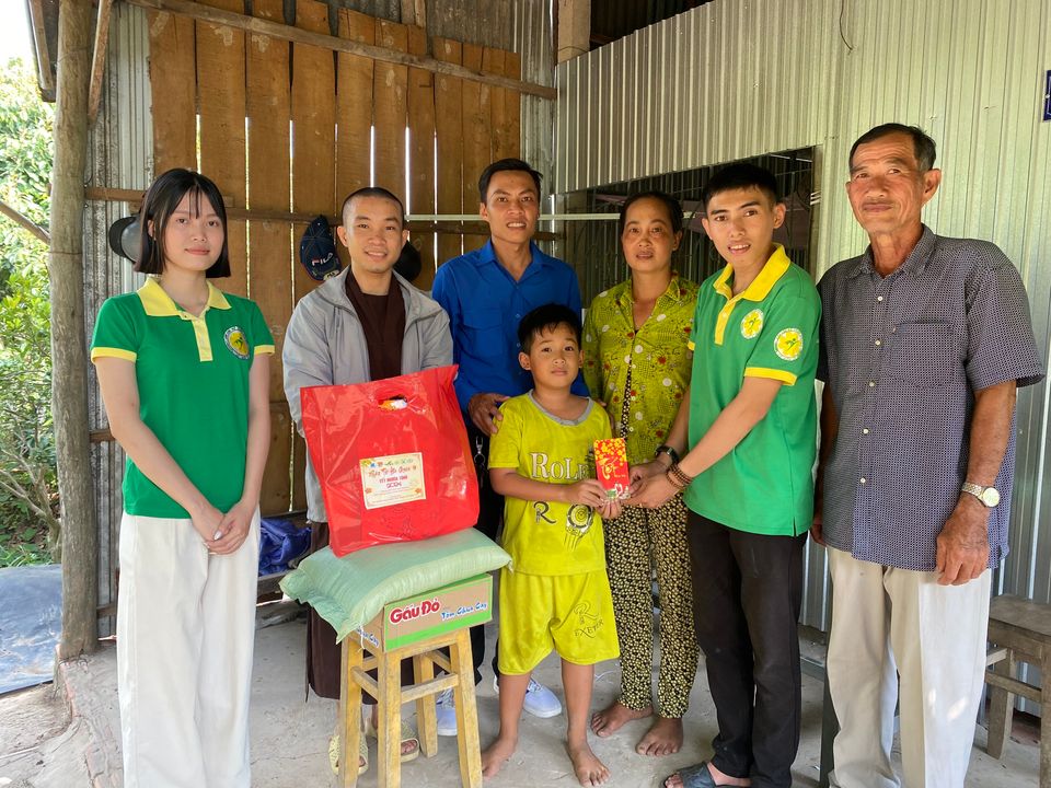 Anh Nguyễn Phước Vinh (thứ 2 từ phải sang) cùng thành viên Câu lạc bộ Thiện nguyện Cỏ Bốn Lá tặng quà Tết cho thiếu nhi có hoàn cảnh khó khăn