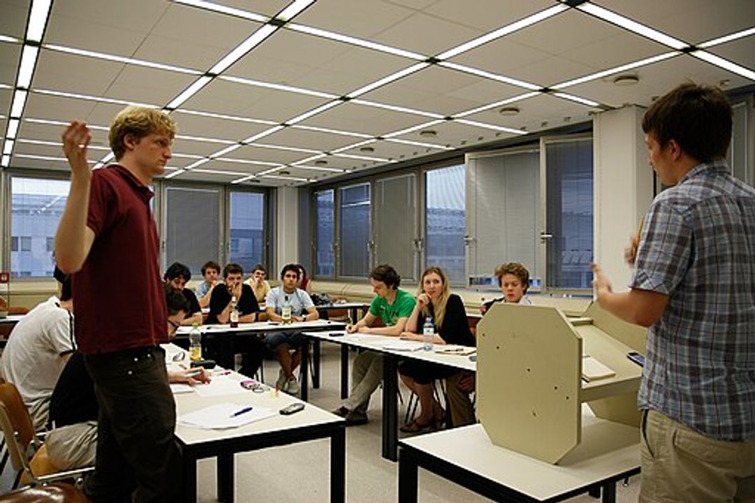 Tôi đề xuất ghép ba chiếc bàn, của giám khảo và hai nhóm thí sinh, lại thành một hình chữ U, với bàn giám khảo tựa lưng vào sân khấu. 