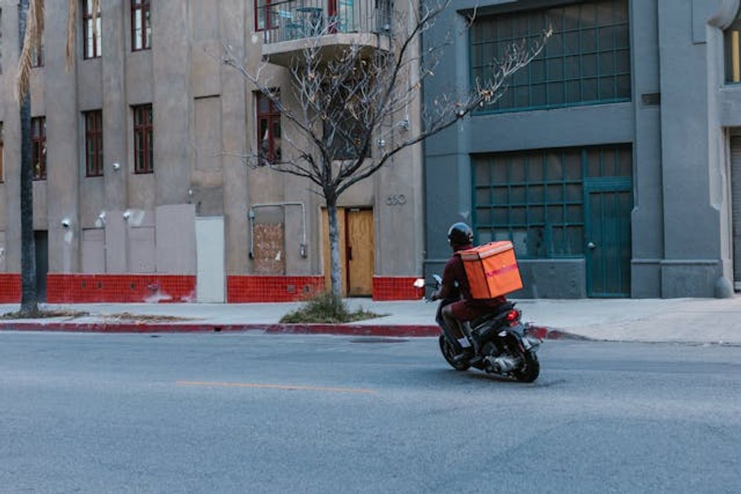 Nhà sư vẫy tay chào, trông theo lưng áo người shipper đang tiến về con đường phía trước.