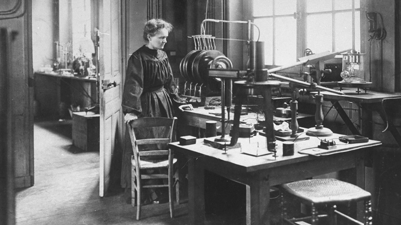 <i>Marie Curie làm việc trong một căn nhà kho ẩm thấp, mái dột, thiết bị thô sơ, không có hệ thống thông gió hay an toàn phóng xạ.</i>
