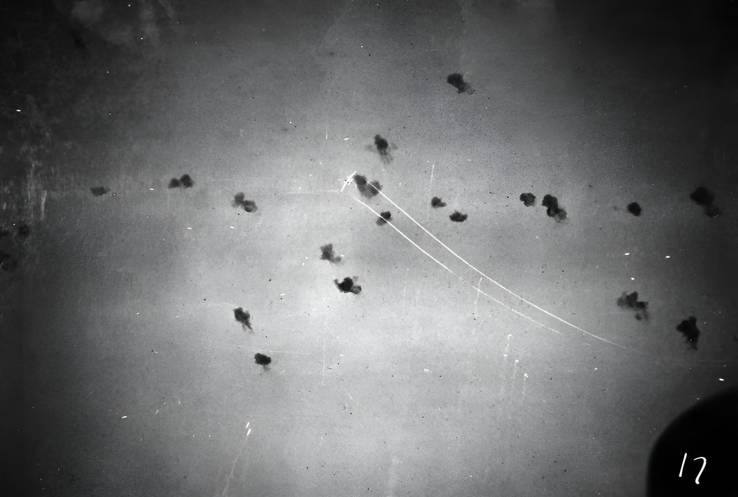 Ảnh chụp từ USS Pensacola cho thấy một chiếc máy bay Type 99 đang bay qua làn hỏa lực phòng không của các tàu hộ tống. Có thể vết trắng từ cánh của máy bay là hậu quả từ việc trúng đạn. (NHHC)