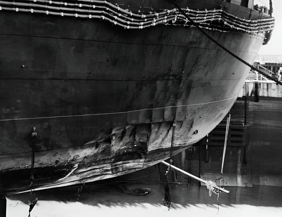 Bức ảnh này cho thấy những thiệt hại do bom gây ra trên tàu Enterprise trong trận chiến Đông Solomon vào ngày 24 tháng 8 năm 1942. Chú ý các dây khử từ bị xé khỏi giá đỡ và lớp vỏ tàu bị lõm ở phần dưới mực nước và sát mực nước biển. Tàu sân bay được nhìn thấy trong ụ tàu tại Xưởng Hải quân Trân Châu Cảng vào ngày 10 tháng 9 năm 1942. (NHHC)