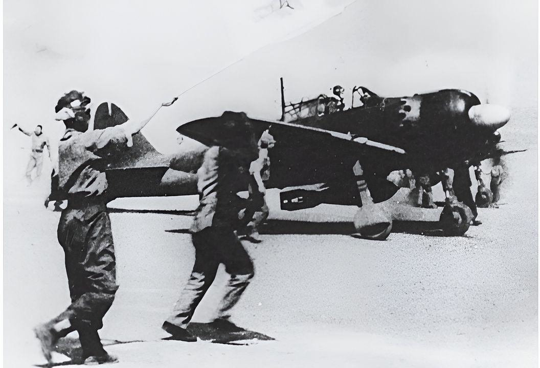 Nhân viên mặt đất và đồng đội vẫy tay chào khi một phi công Đơn vị Tấn công Đặc biệt điều khiển chiếc A6M5 mang bom lăn ra đường băng chuẩn bị cất cánh từ một căn cứ ở Philippines vào tháng 10 hoặc tháng 11 năm 1944. (Bộ sưu tập Robert Lawson, NMNA)