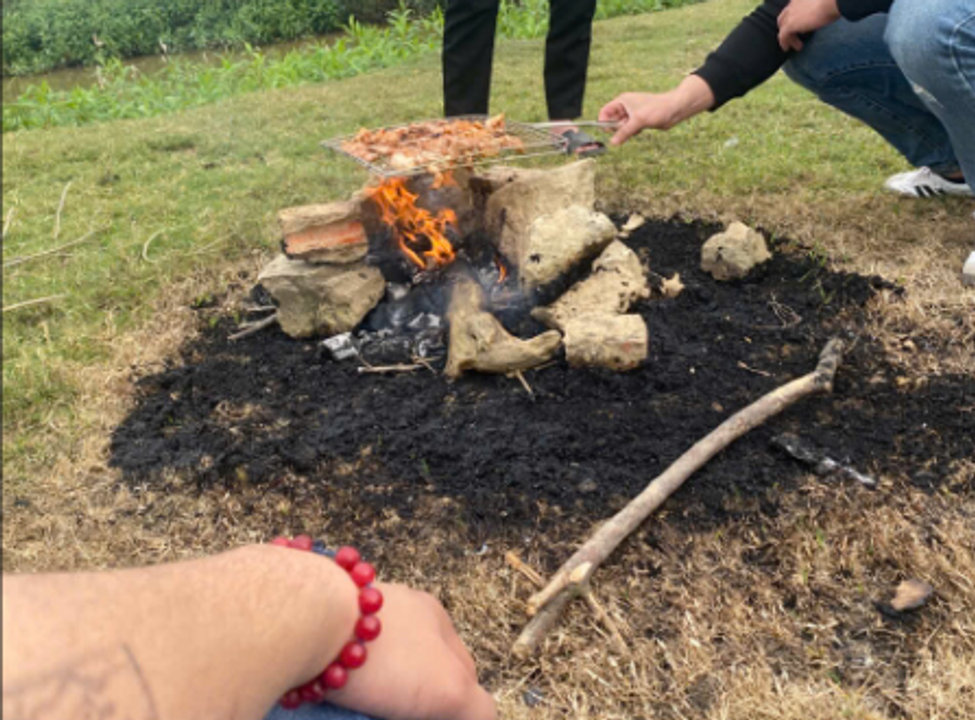 Tôi bên đống lửa trại. Nướng thịt ở dưới cạnh sườn đê.