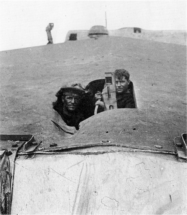 Hai thủy thủ Anh đang nhìn qua một lỗ đạn pháo trên mái tháp pháo trước của thiết giáp tuần dương Tiger. Tổng cộng, con tàu bị trúng 15 phát đạn pháo cỡ 11 inch trong trận Jutland, khiến 24 thành viên thủy thủ đoàn thiệt mạng và thêm 46 người khác bị thương. (IWM SP 1597)